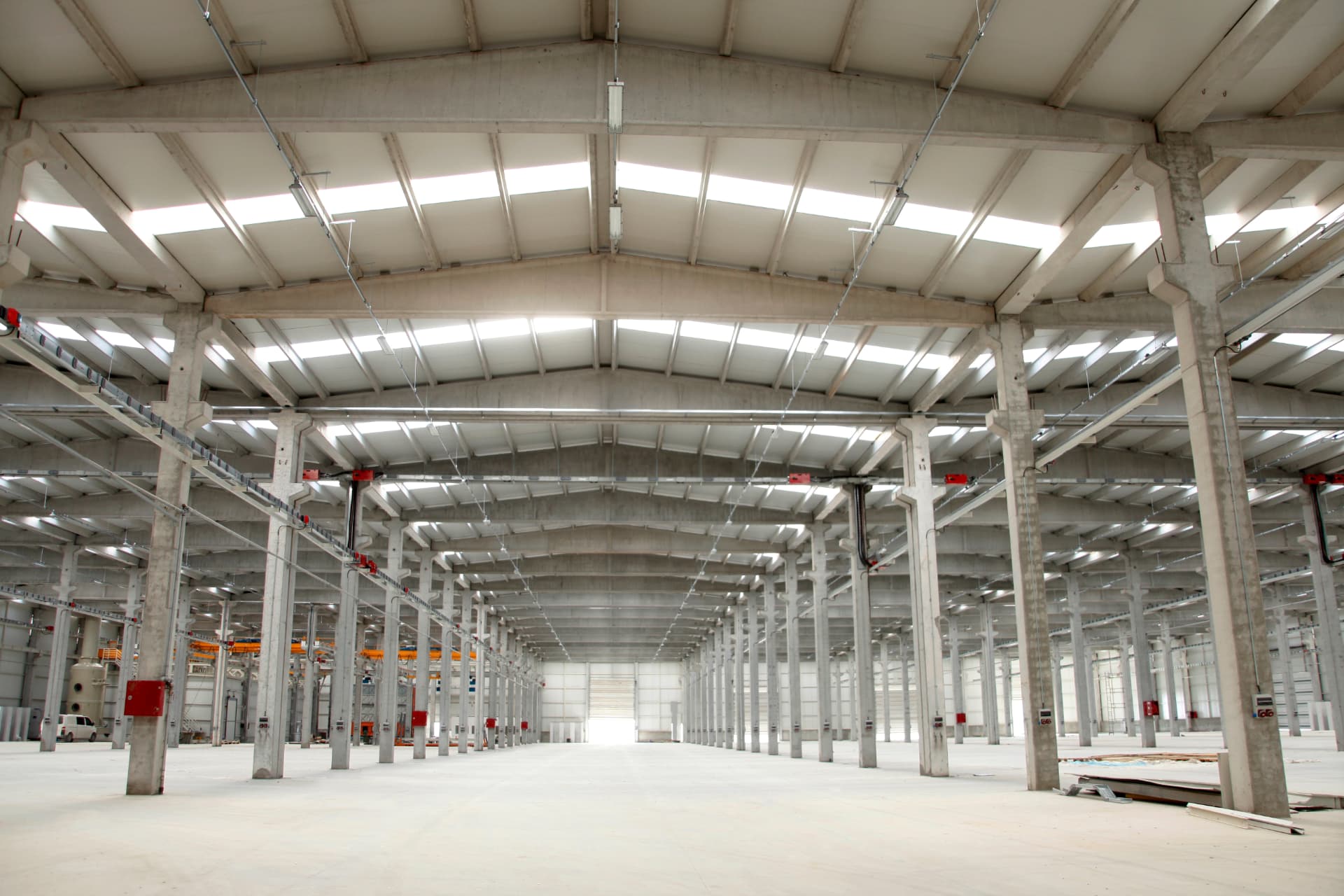 Entrepôt industriel à structure de béton, dalle nue et puits de lumière
